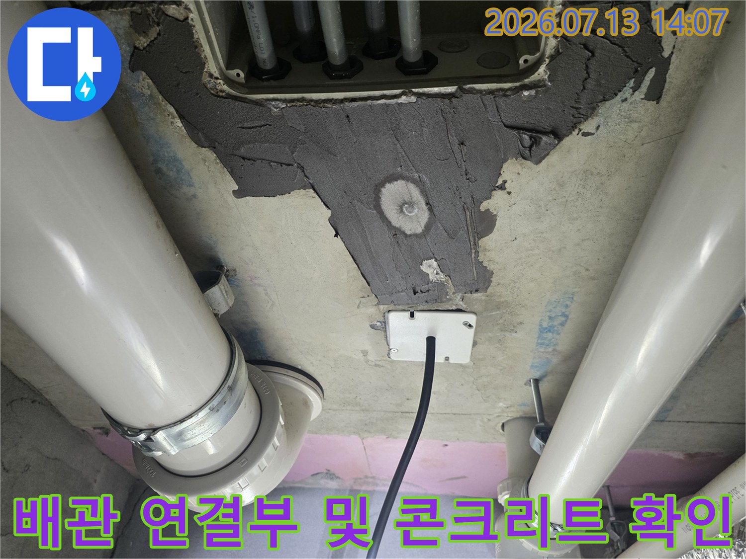 화장실 천장 배관 주변의 파손된 콘크리트와 누수 추적을 위한 점검용 부품 상세 사진