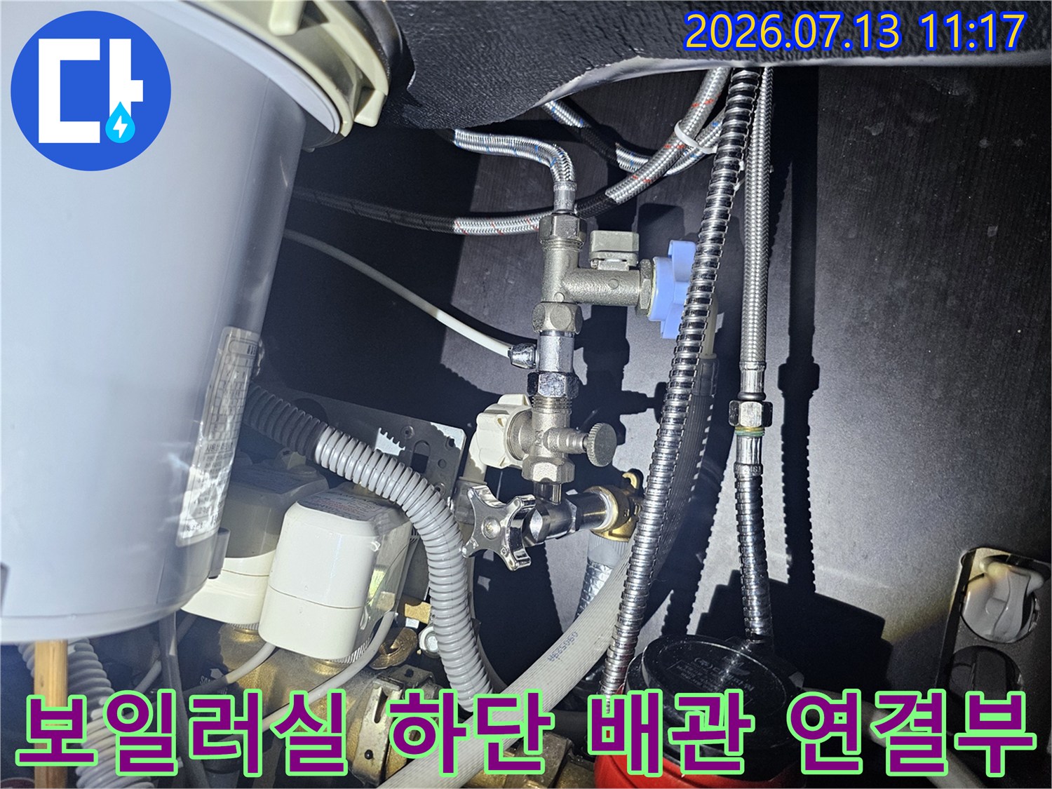 보일러 아래쪽의 복잡한 금속 배관과 밸브-연결 부위 사진