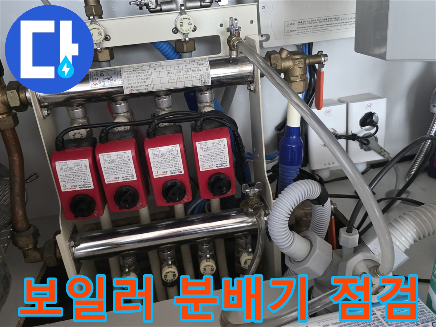 분배기에 연결된 붉은색 밸브들과 하단 배관의 누수 여부를 확인하는 엔지니어의 시선입니다.