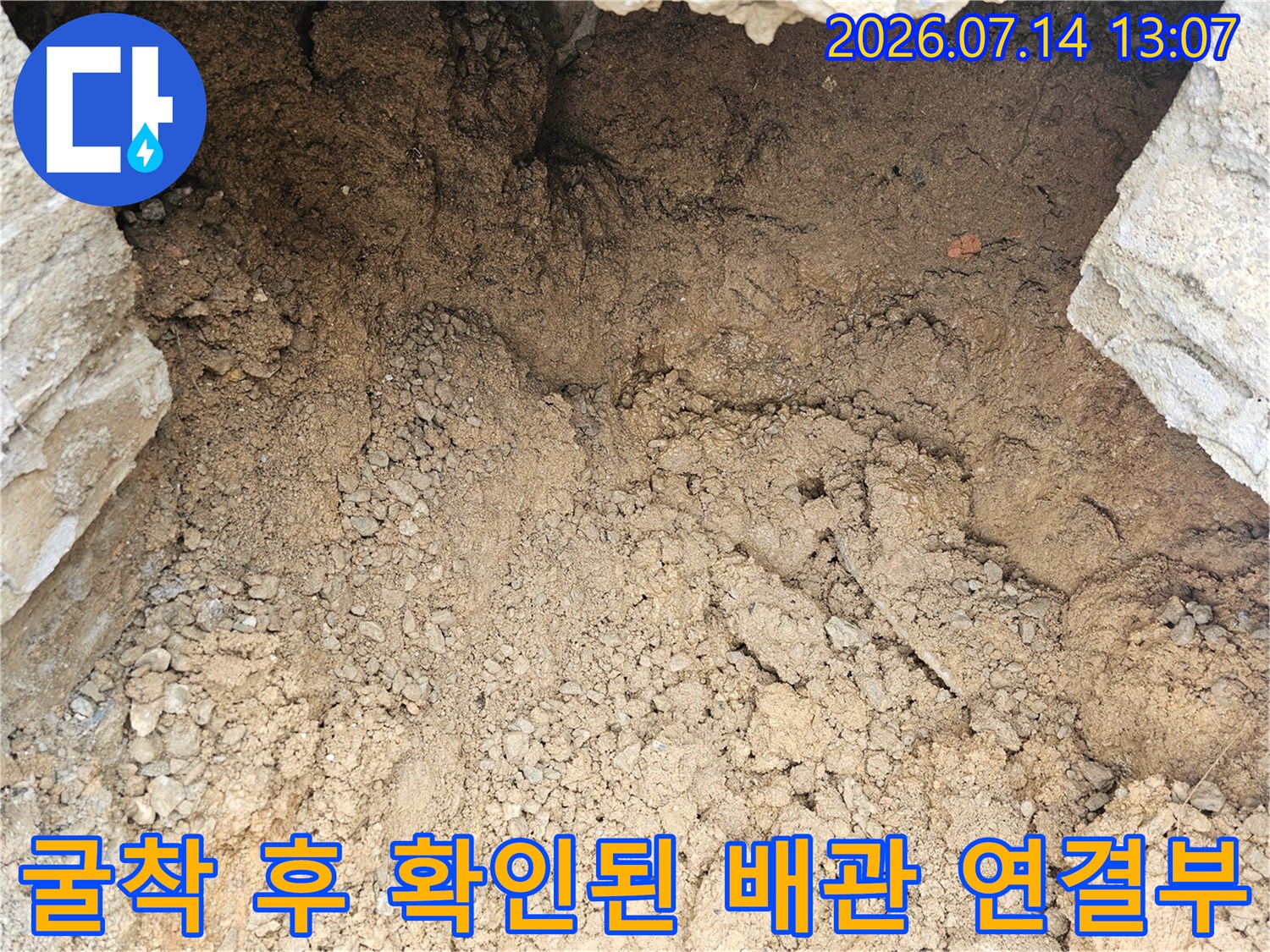 젖은 흙 속에 파묻혀 있던 누수 배관의 단면과 주변 환경