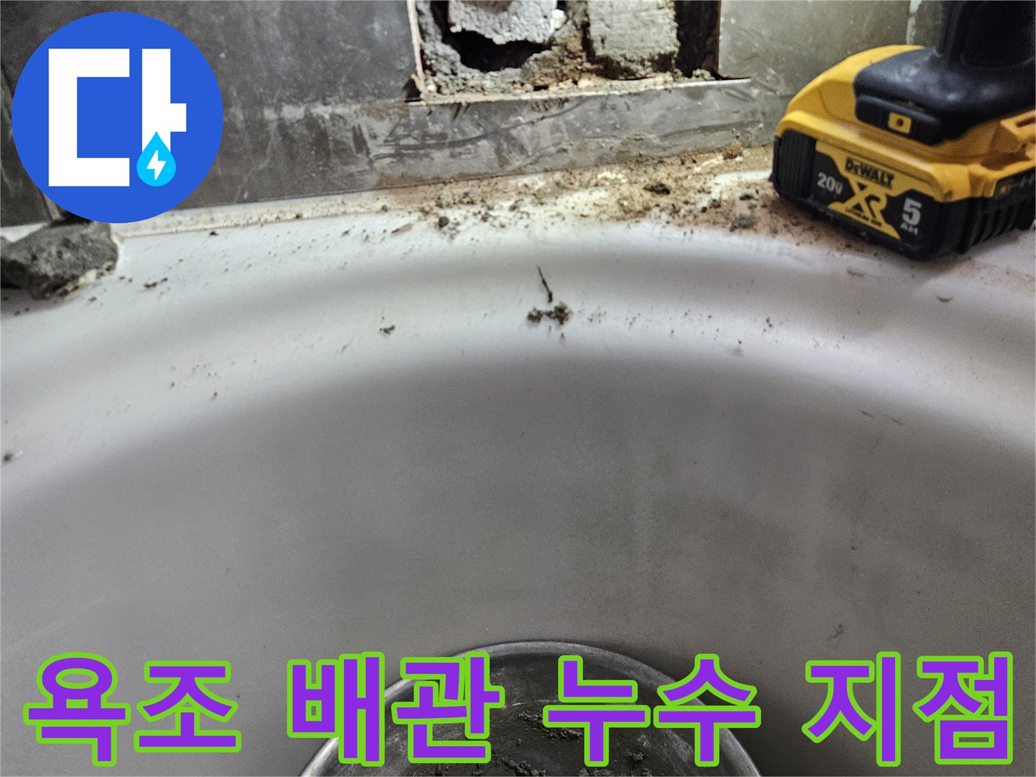 욕조 내부-파손된 타일과 노출된 배관의 상태를 보여주는 사진