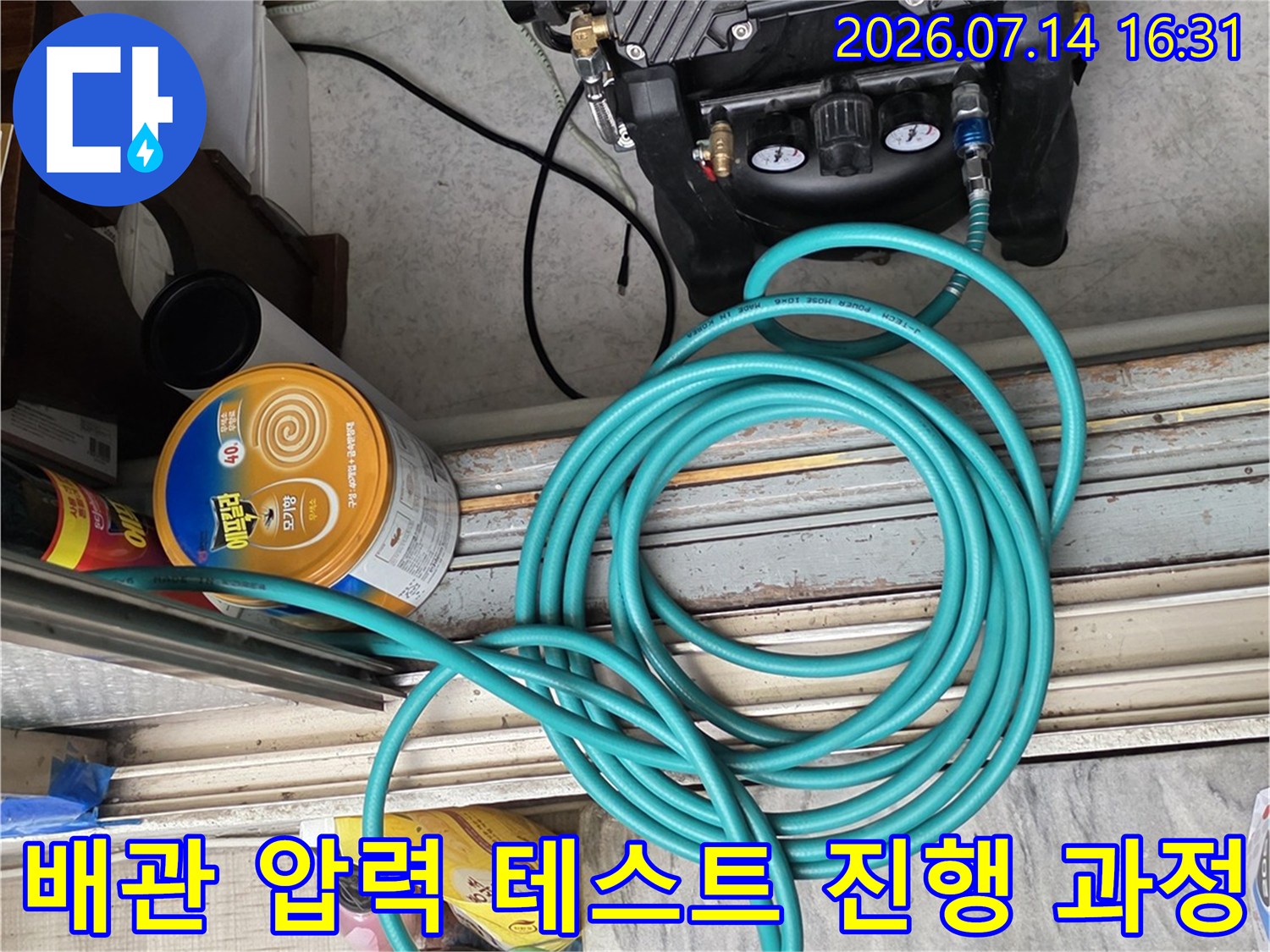 가스 공급 장치와 긴 호스를 연결하여 배관을 점검하는 모습