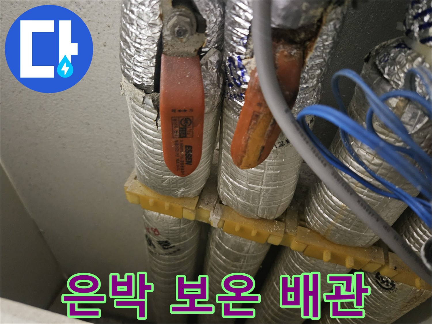 노란색 고정재로 묶인 은박 보온재 배관