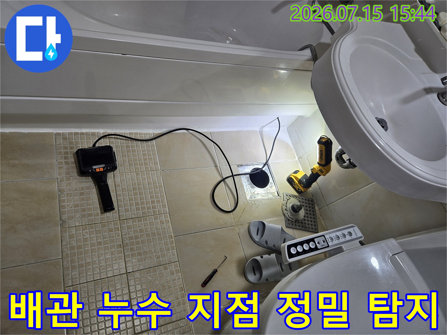 세면대 밑 배관 연결부를 전문 장비로 점검하는 모습