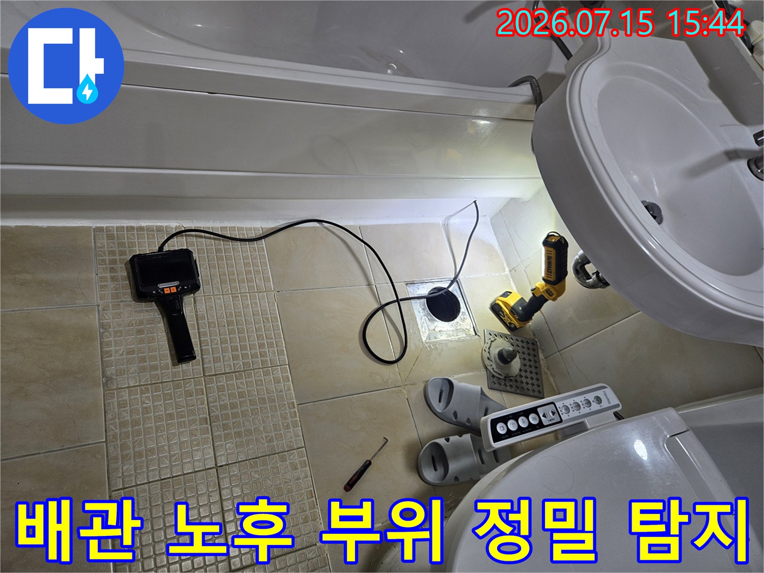 세면대 밑 배관부근에 배치된 청음 장비와 전동 공구