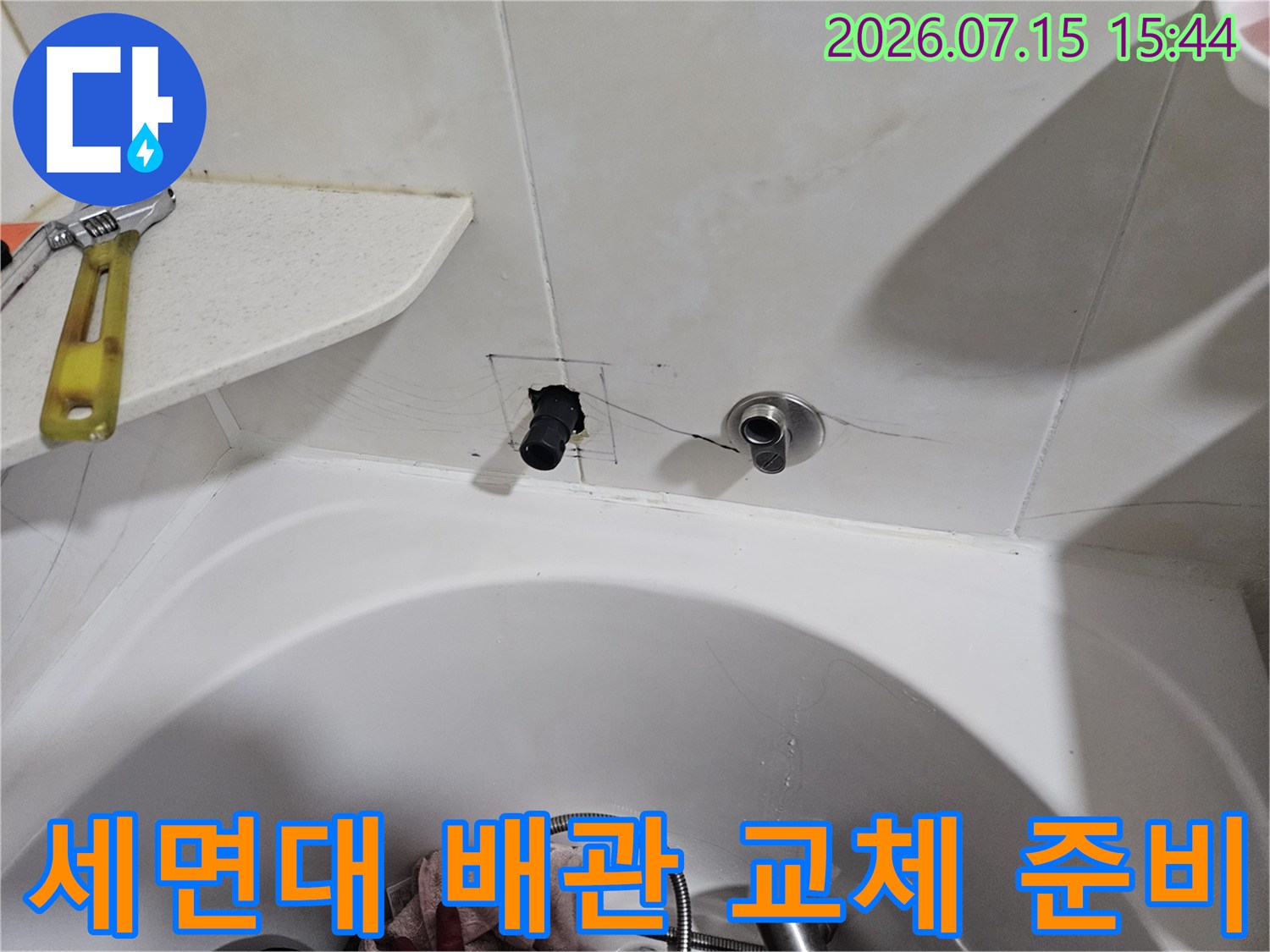 세면대 아래 위치한 노출 배관과 연결 부위를 점검하는 모습