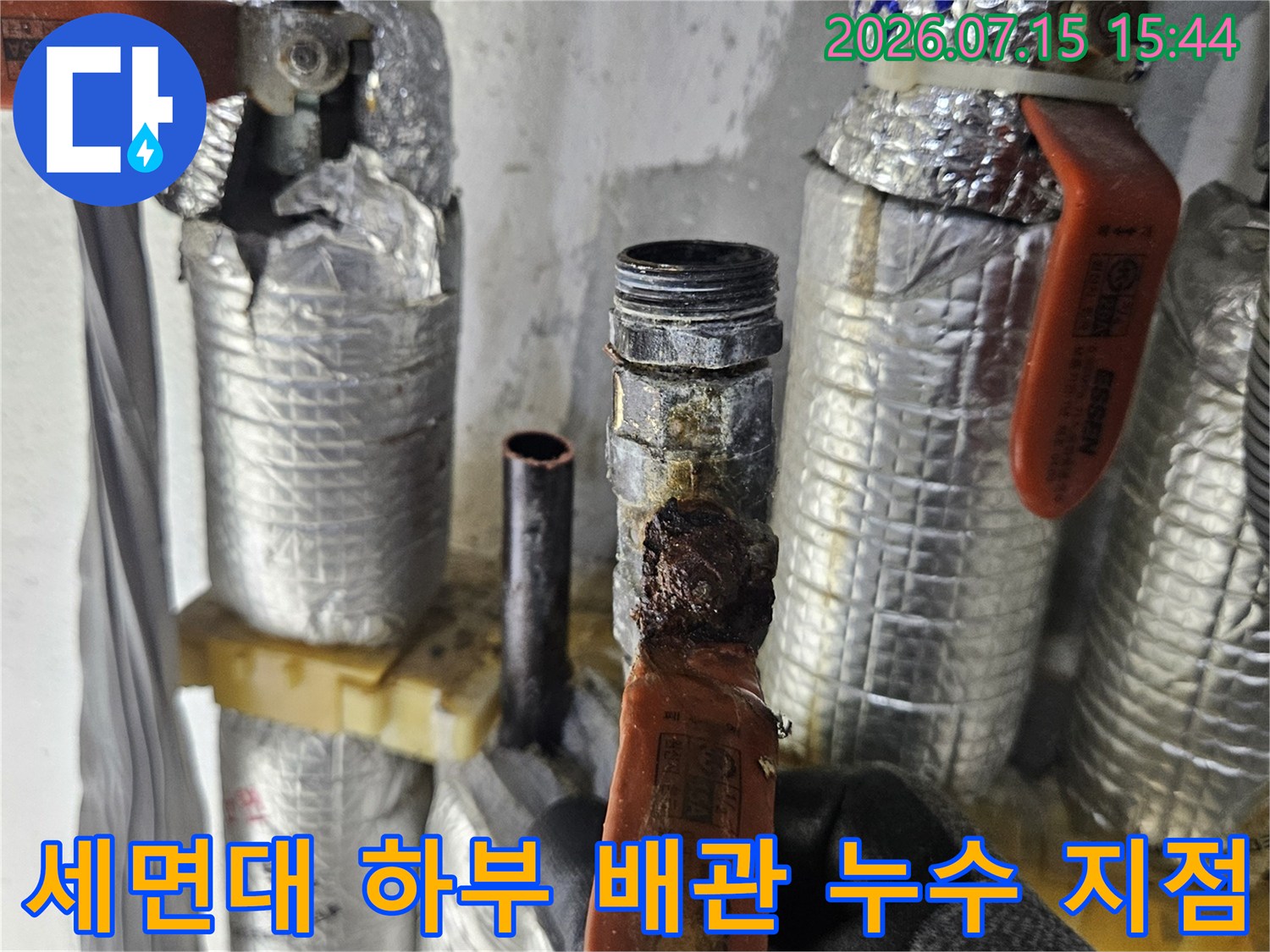 은박 마감재로 덮인 세면대 아래 온수 배관 연결 부위 모습