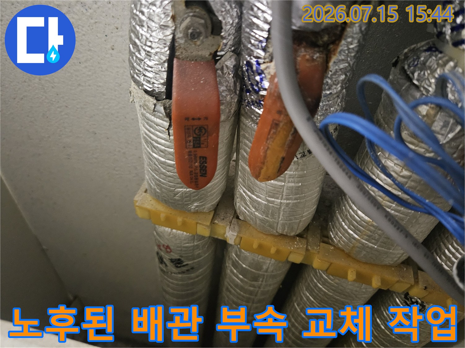 은박 보온재로 감싸진 배관 사이에서 노출된 주황색 온수 배관 부속 부위
