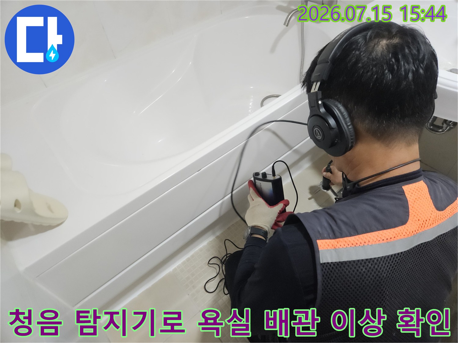 작업자가 청음 장비를 착용하고 세면대 하부의 누수 지점을 소리로 정밀하게 추적하는 모습