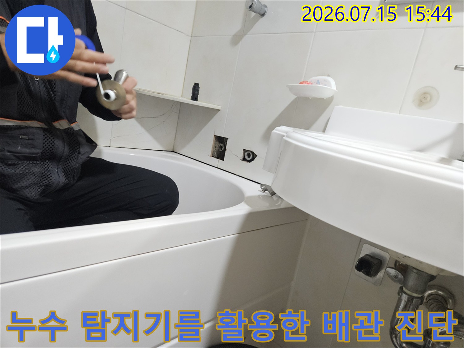 전문가용 탐지 기기로 세면대 하부의 누수 지점을 정밀하게 파악하는 모습