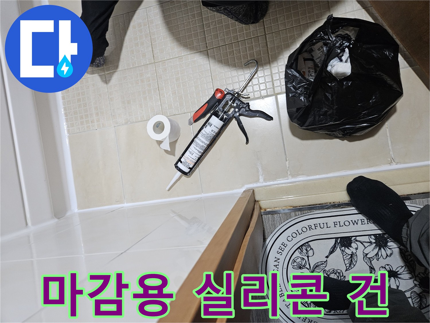 타일 바닥에 놓인 실리콘 건과 작업 소모품