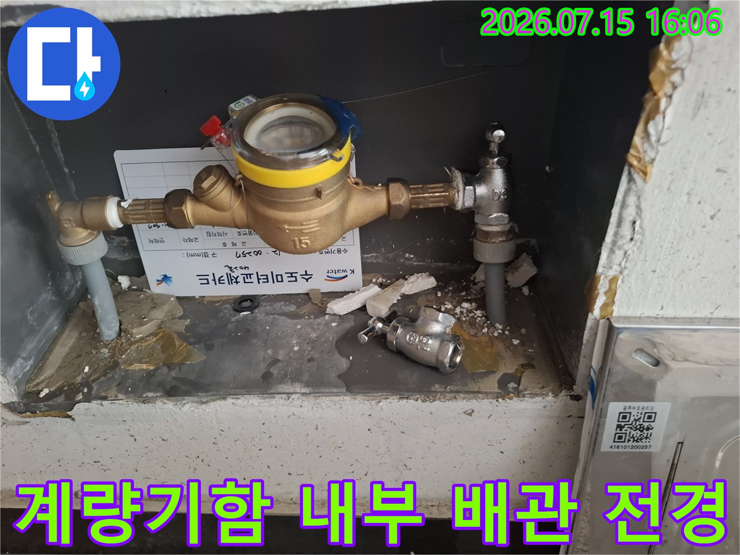 노란색 표시가 있는 수도-계량기와 은색 금속 밸브가 연결된 모습의 사진