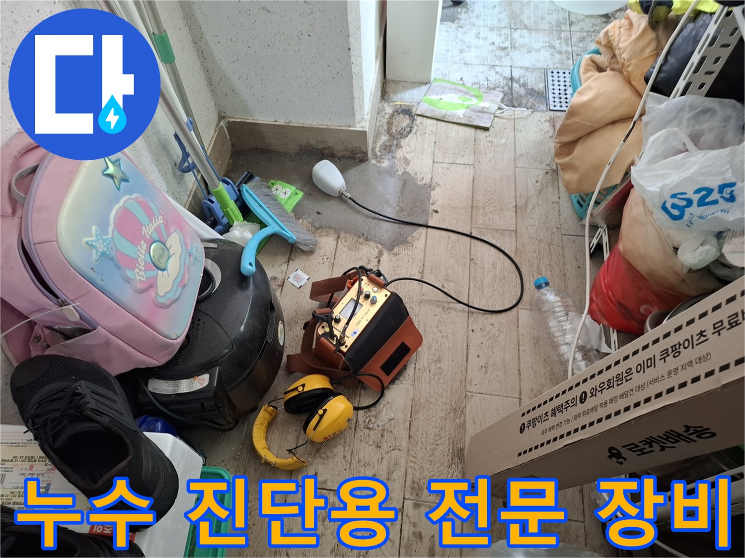 바닥에 놓인 청음식 누수 탐지기와 헤드선 연결 상태