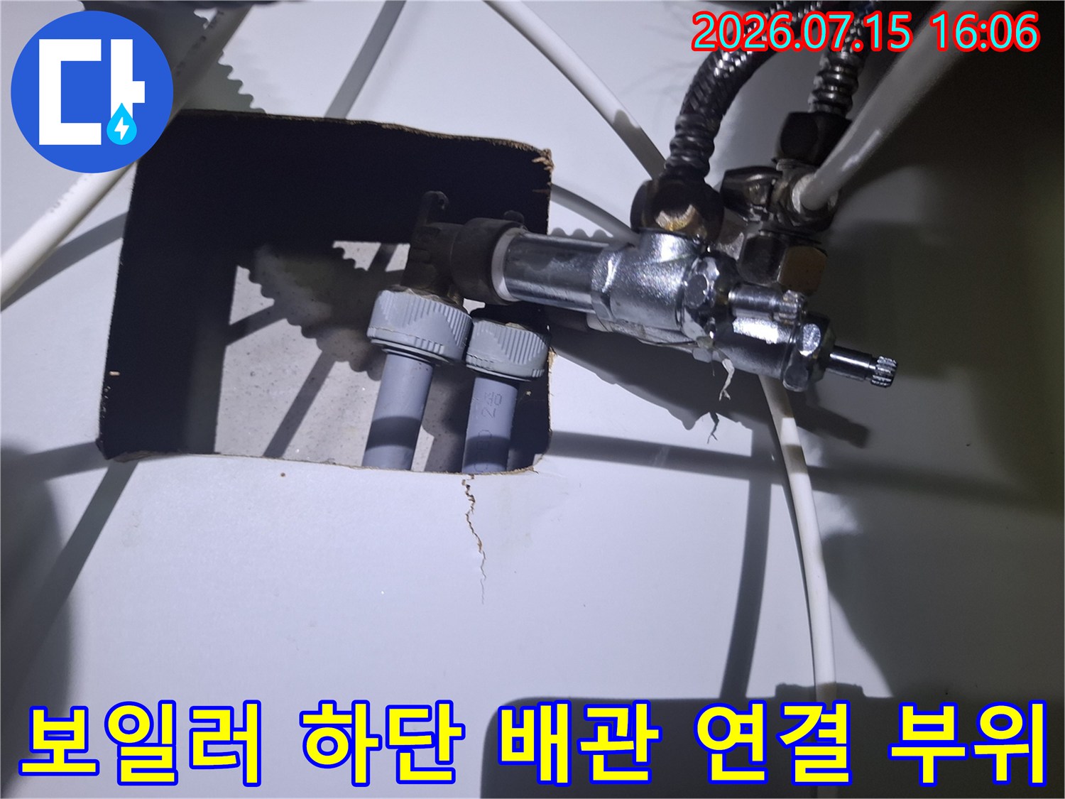 흰색 외벽 내부의 보일러-연결-부속과-회색-배관이-설치된-모습