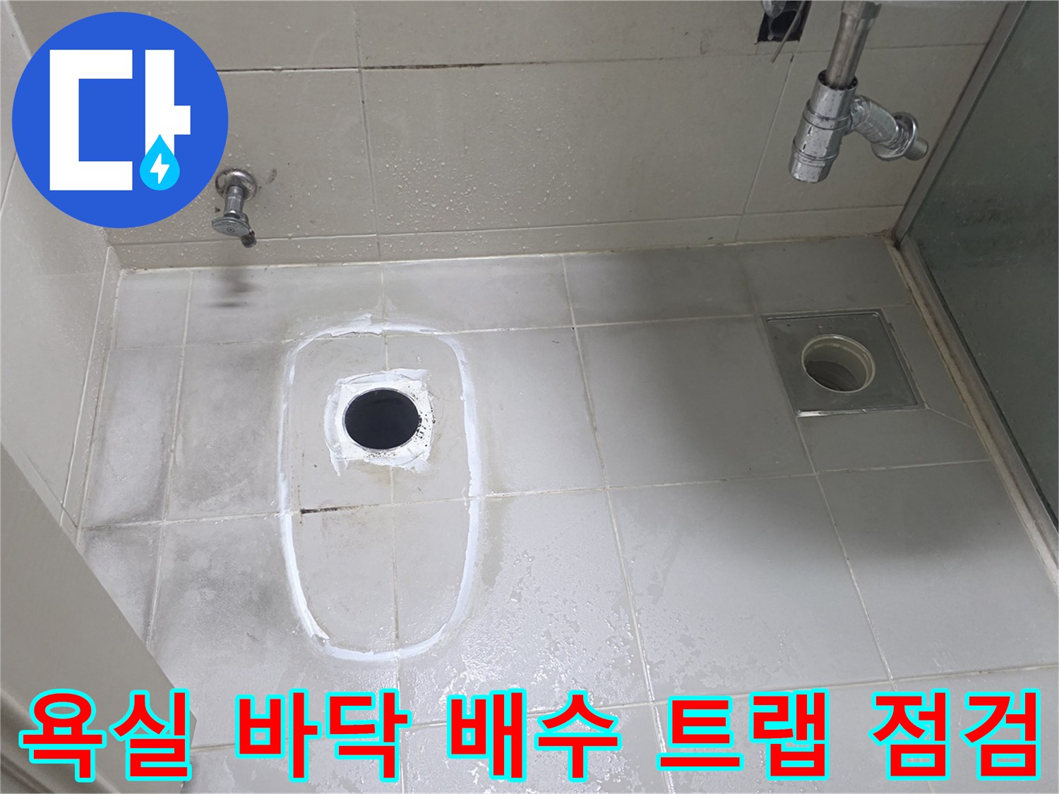 물기가 서린 화장실 바닥 타일과 배수구 근처 모습