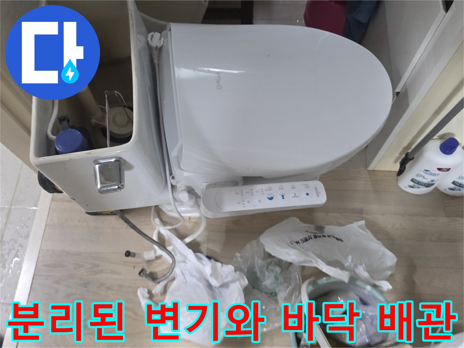 변기 탈거 후 노출된 하부 배관과 작업용 세제 용기들