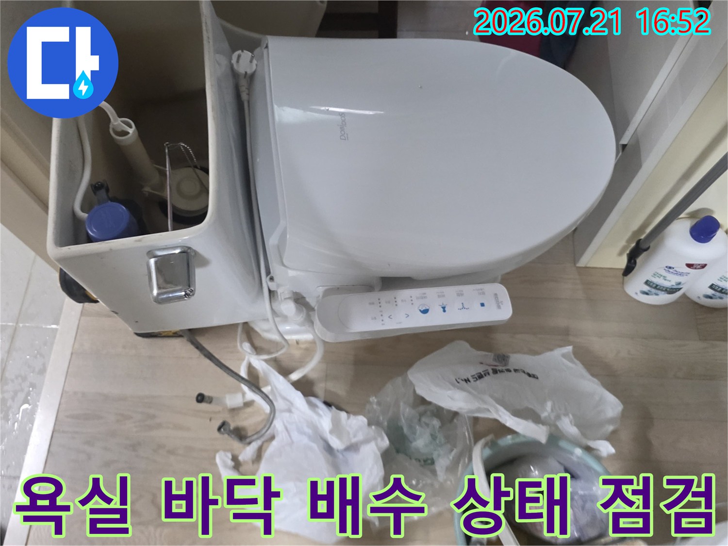 변기 하부 구조와 연결된 배관 주변의 누수 여부를 파악하는 장면