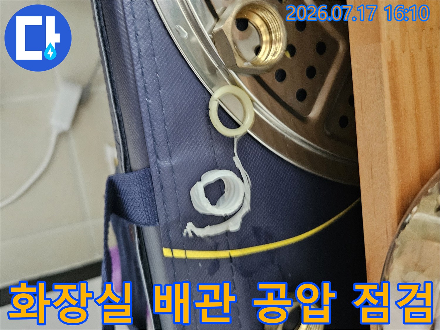 배관 연결 부위와 압력 측정용 장비가 설치된 화장실 내부 모습