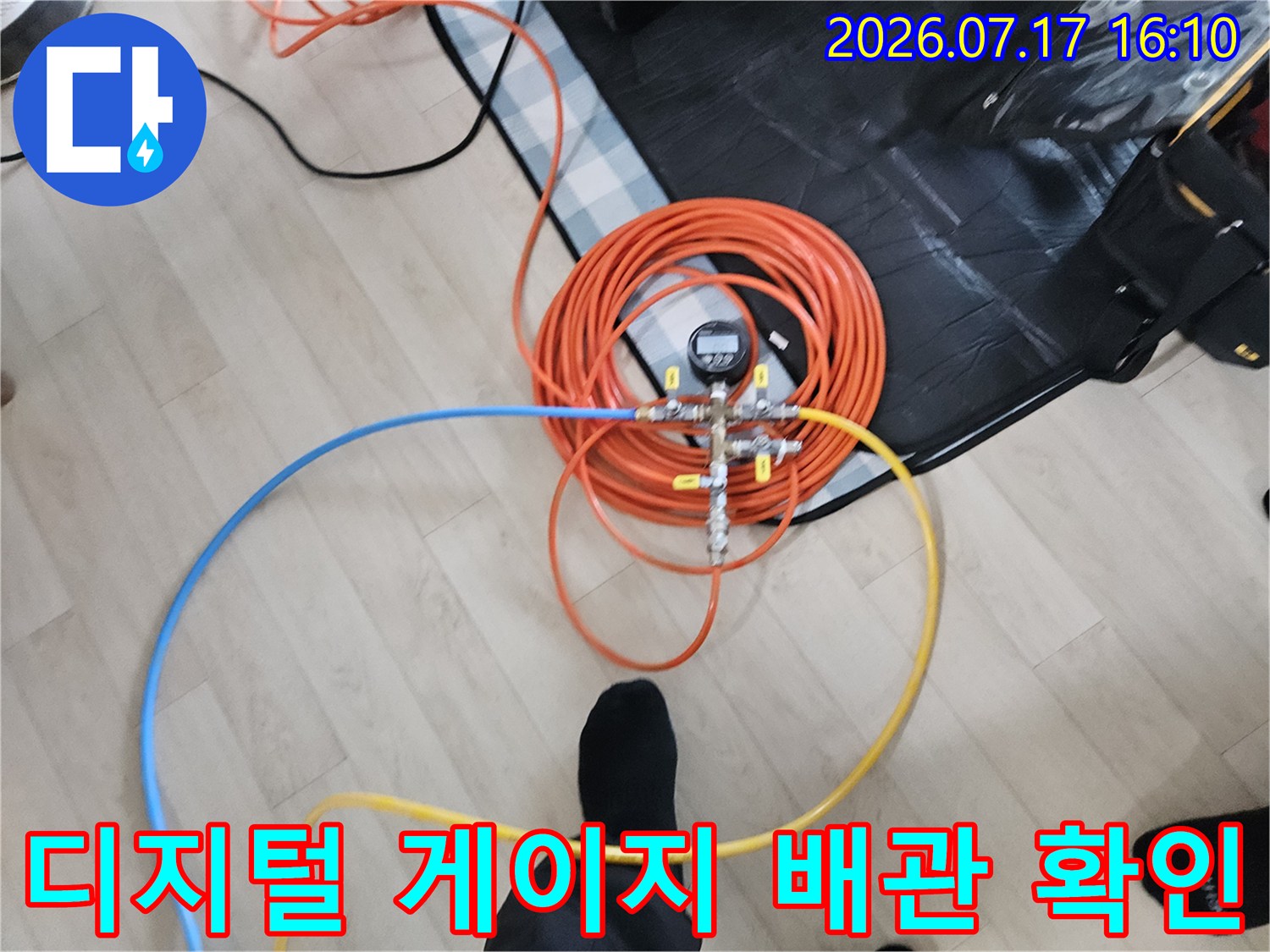 오렌지색 배관 호스와 디지털 측정기기가 연결된 누수 점검 현장