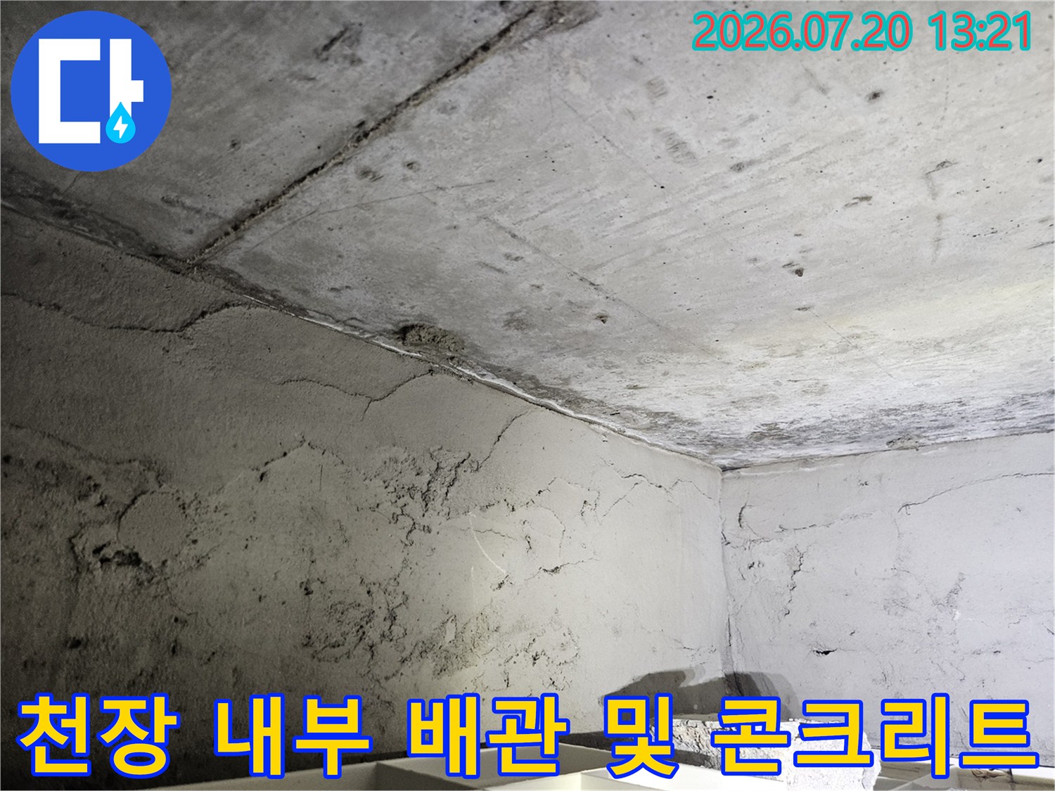 거친 질감의 콘크리트 천장과 얽힌 노후 배관 구조