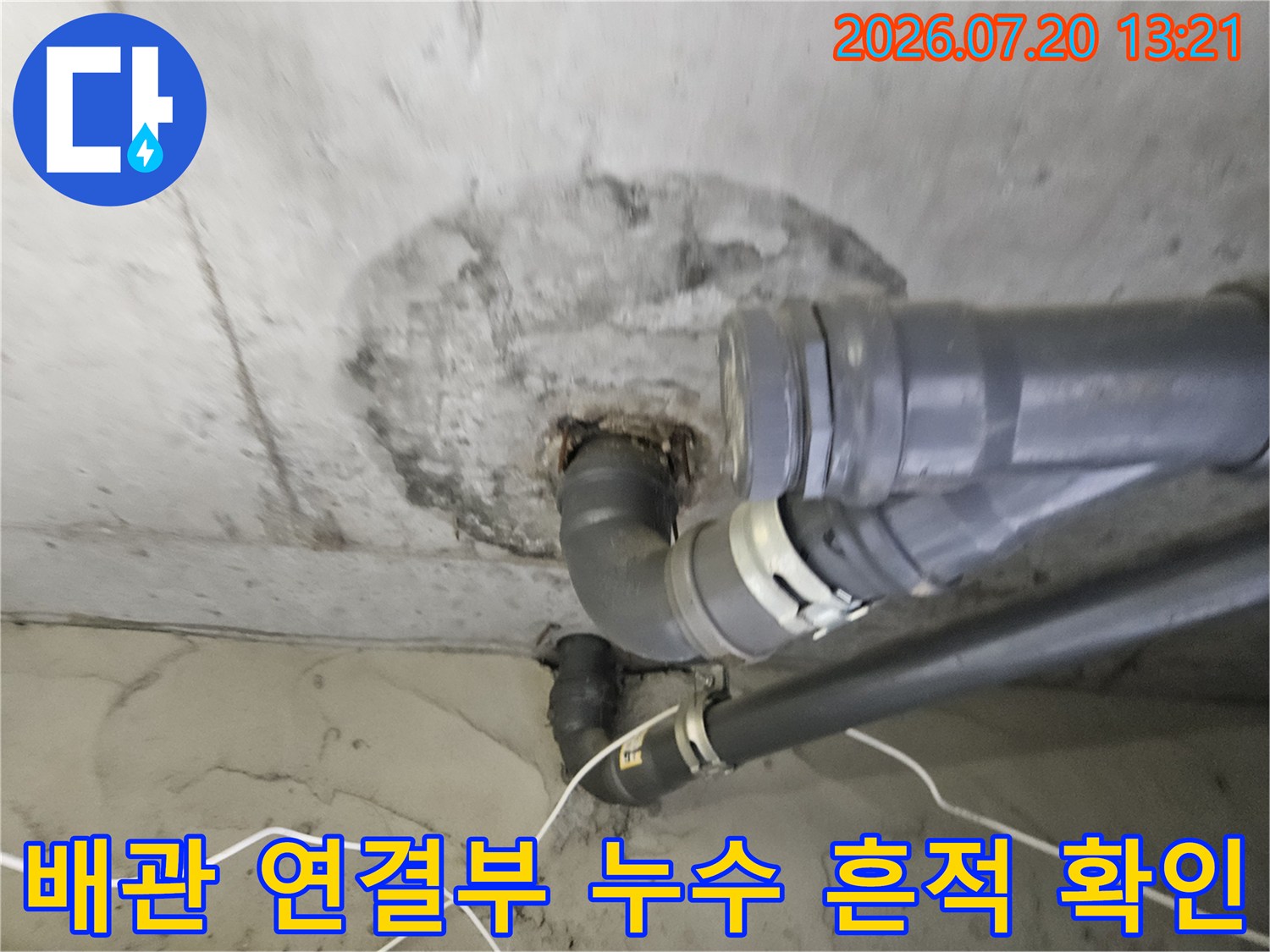 콘크리트 천장에 노출된 배관 파이프와 주변의 변색된 오염 부위
