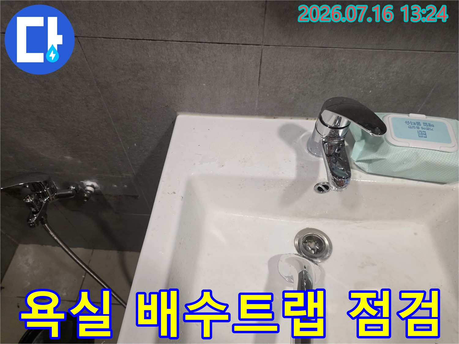 세면대 하부 트랩과 연결 호스를 세밀하게 조사하는 현장 상황