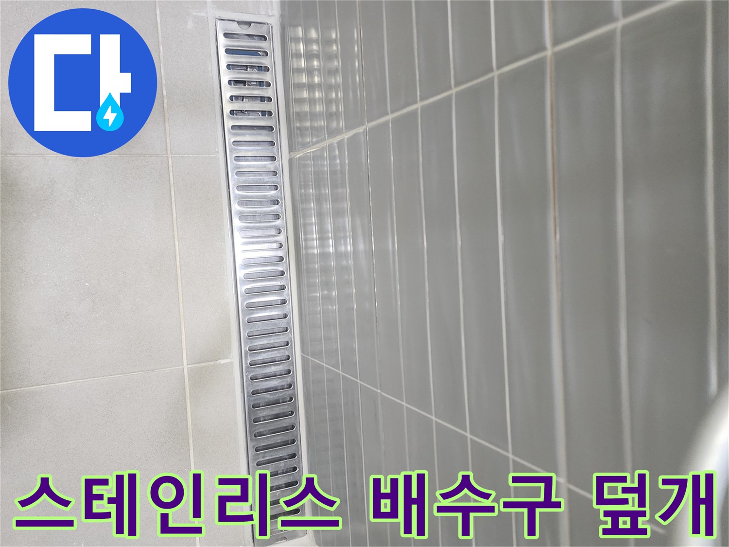 화장실 바닥에 설치된 스테인리스 재질의 긴 배수구
