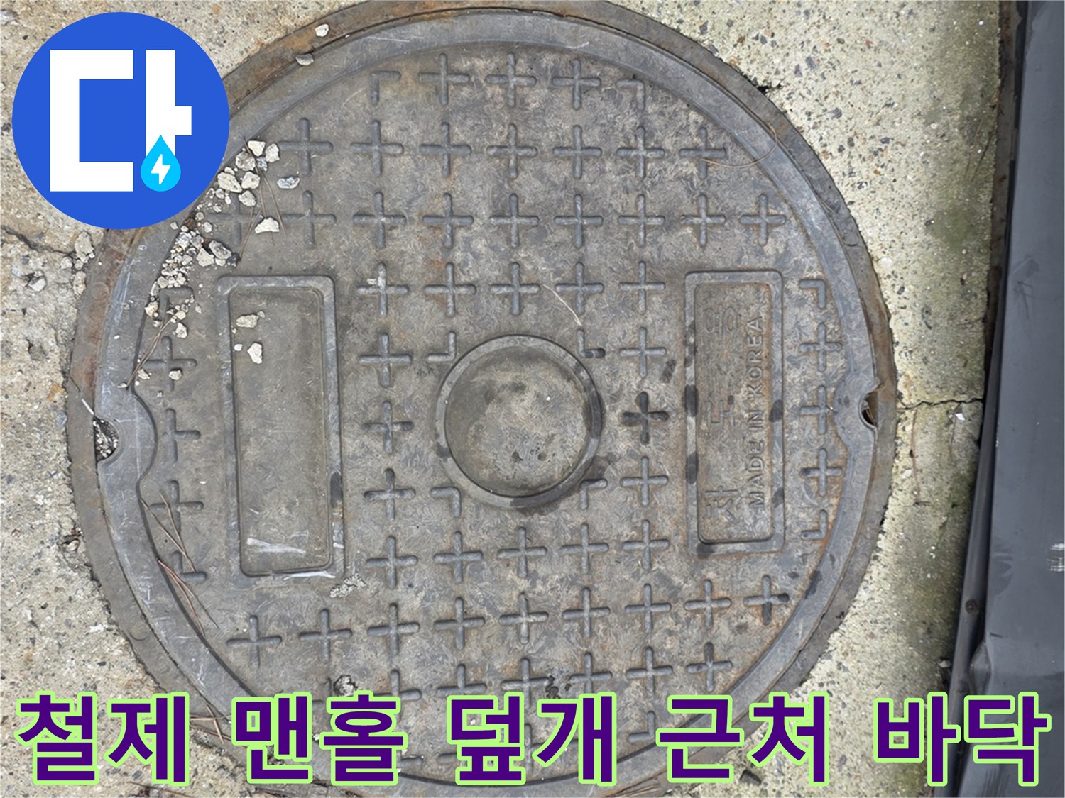 거친 질감의 콘크리트와 금속 맨홀 구조물
