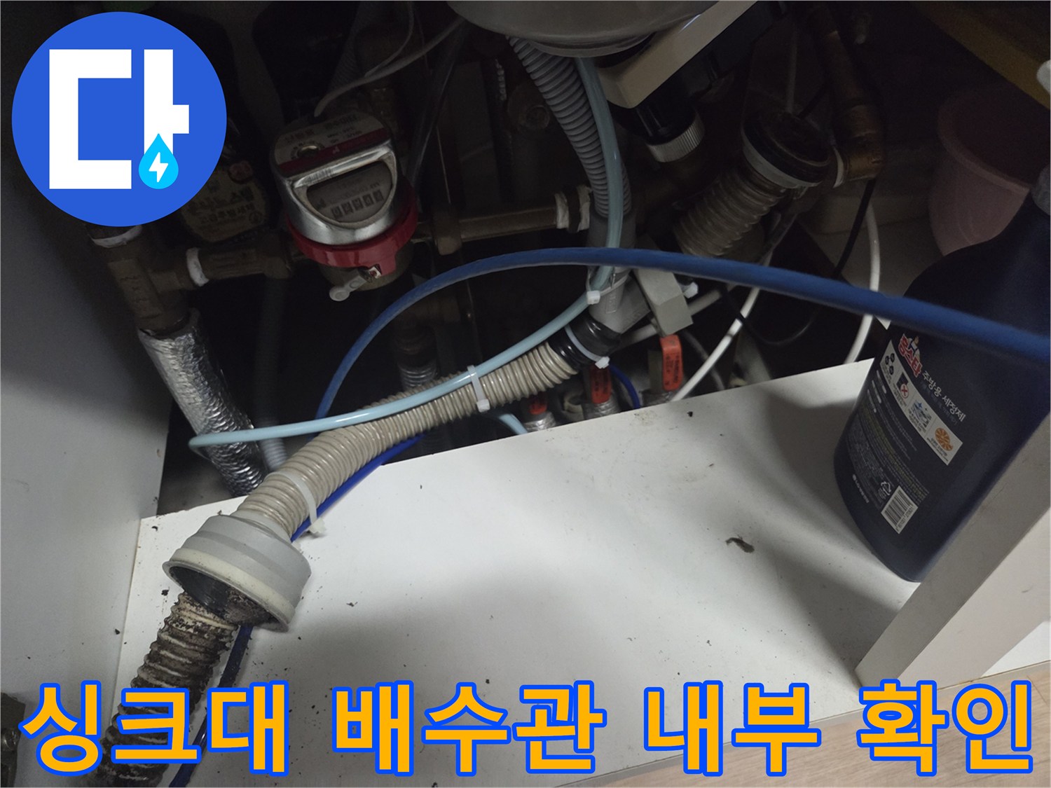 식기세척기와 연결된 싱크대 하부의 복잡한 배관 구조물