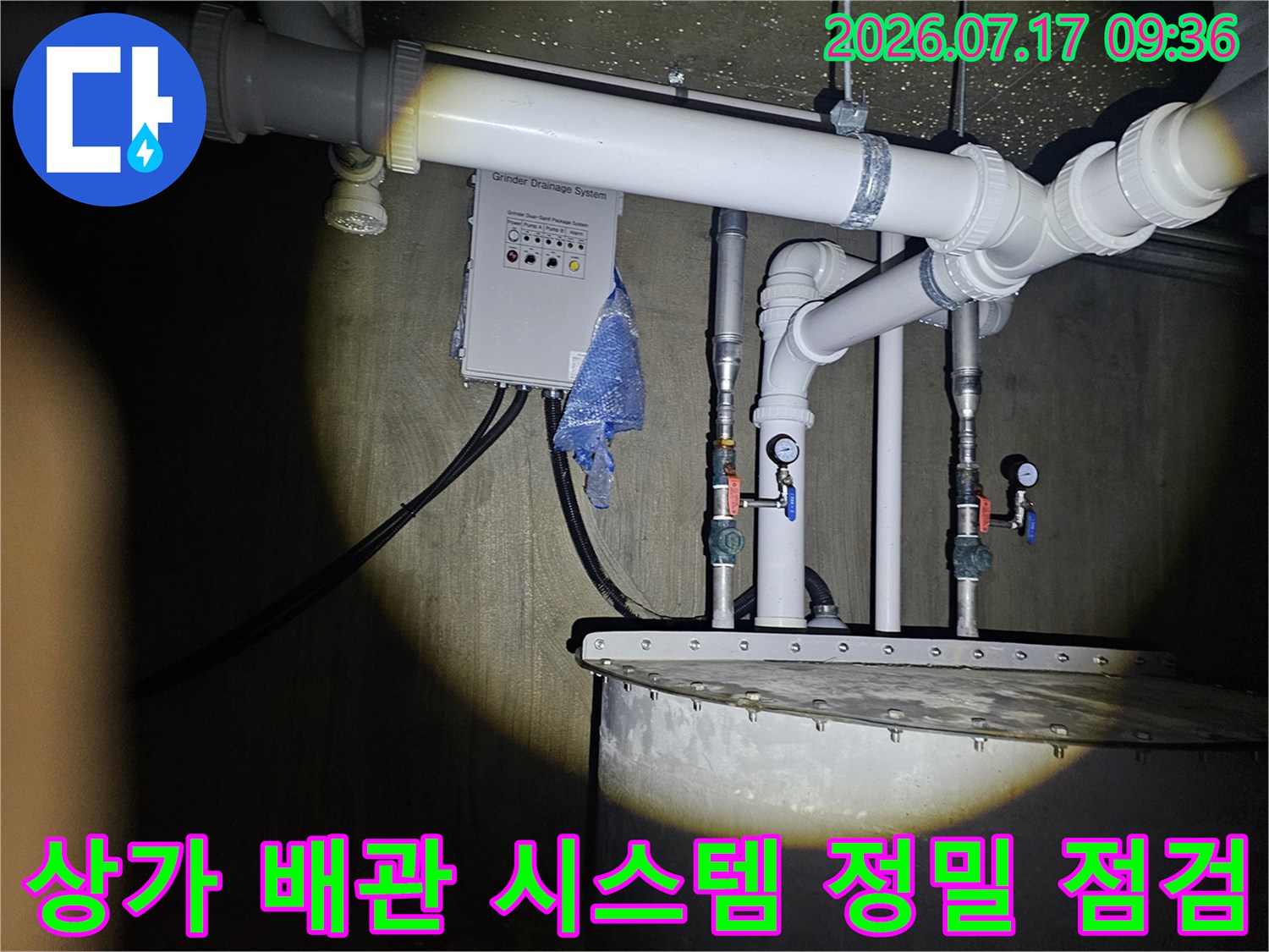 상업 시설 내 수도 계량기와 연결된 복잡한 배관 구조를 진단하는 모습