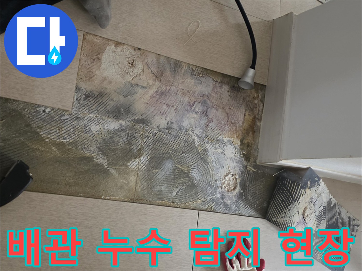 바닥재를 들어내고 가스 탐지기를 사용하여 배관을 점검하는 모습