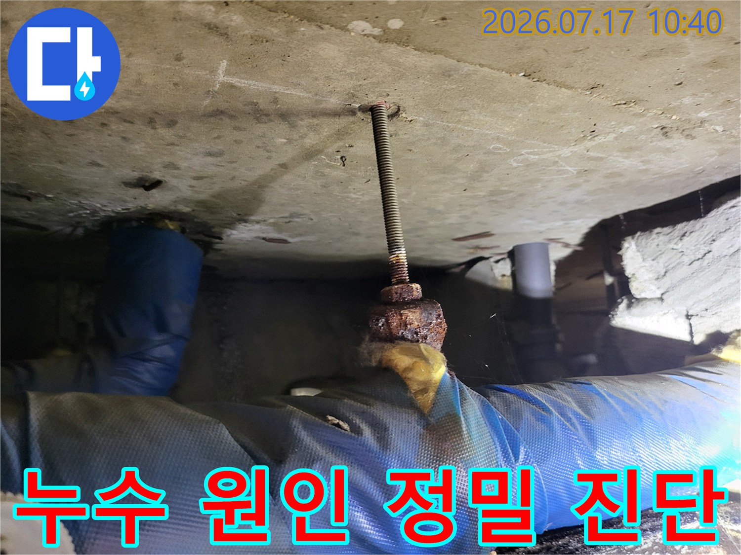 천장 내부에 노출된 배관 및 고정 장치의 부식 상태를 확인하는 모습