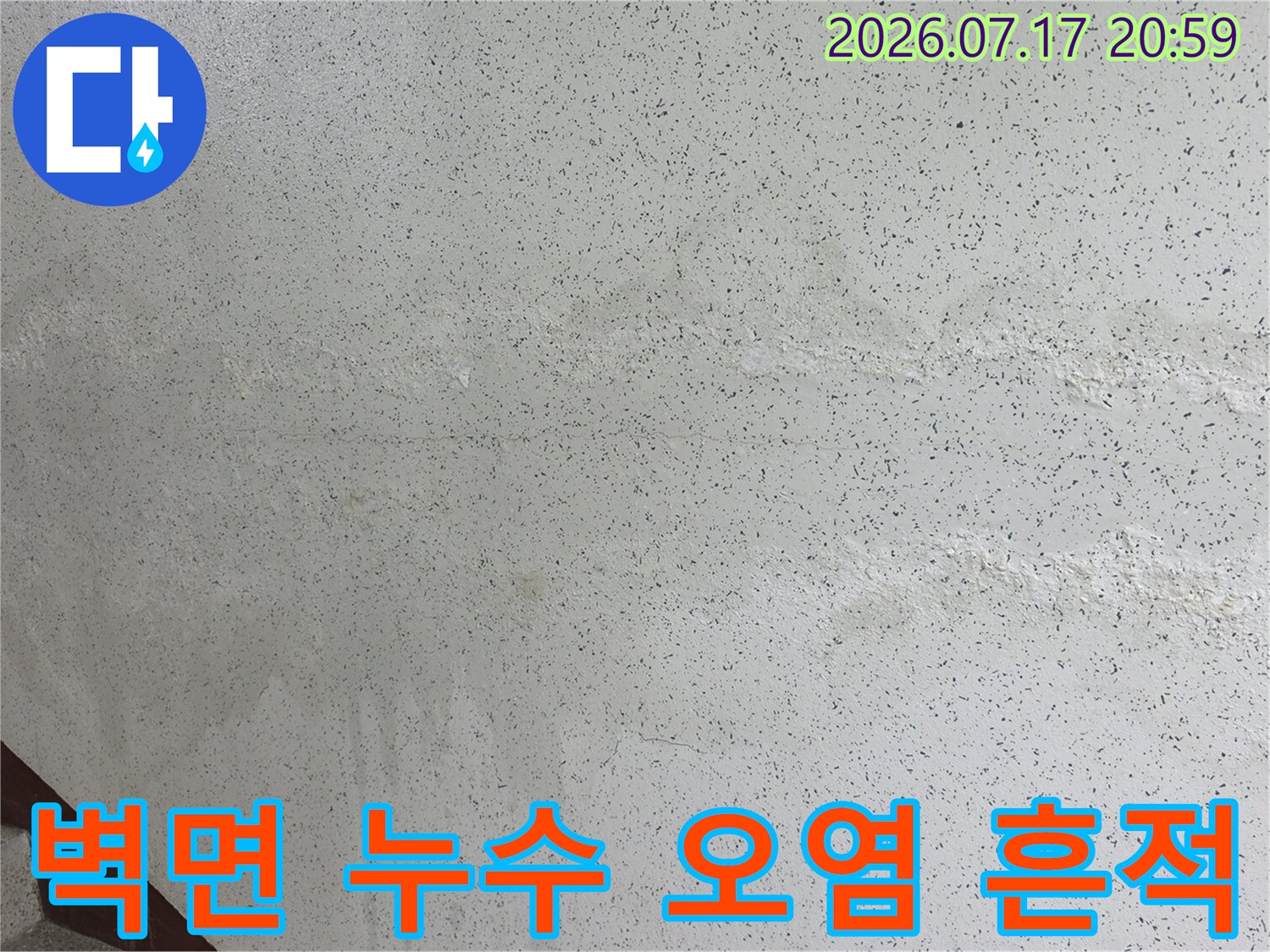 계단 옆 콘크리트 벽면에 발생한 수분 침투 변색 현상
