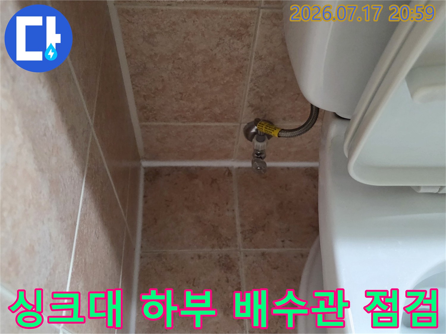 싱크대 아래 노출된 배수용 파이프와 연결 부위 모습