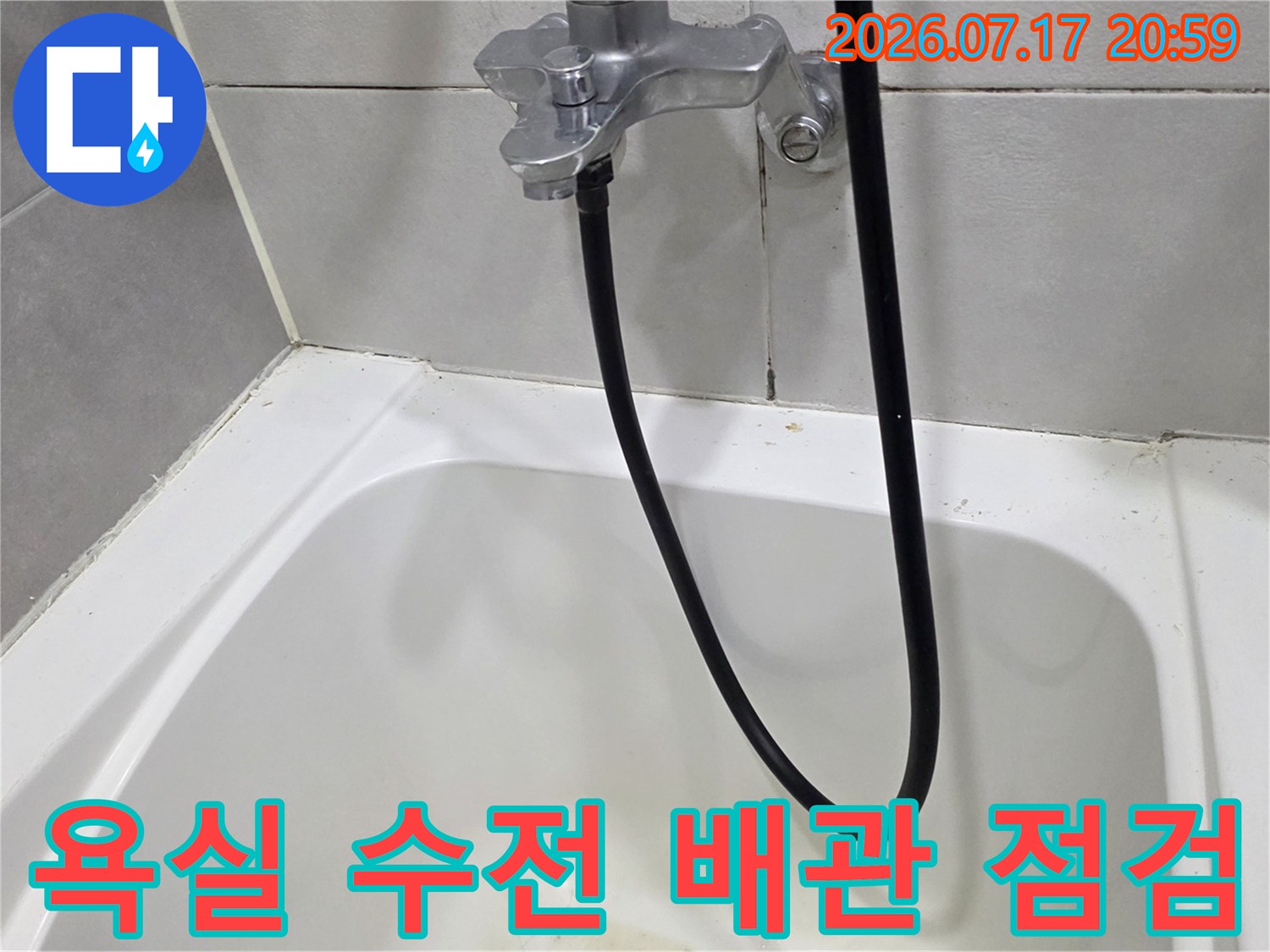 은색 샤워 헤드 연결부와 검정색 호스라인을 촬영한 사진