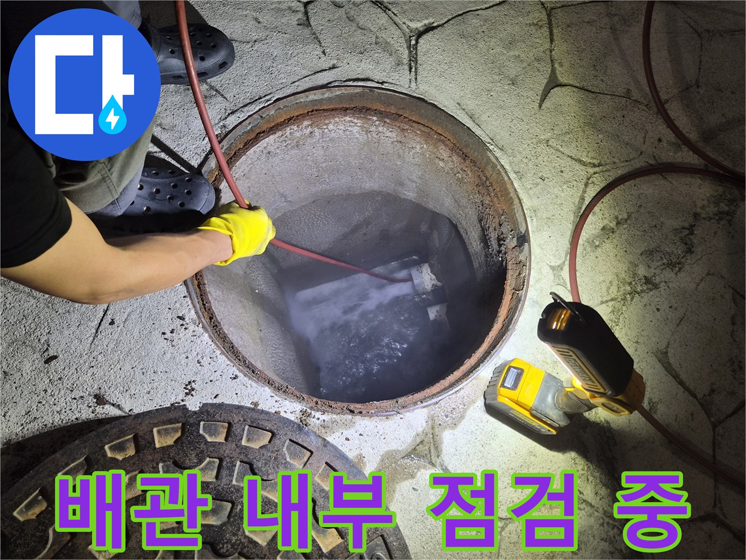맨홀 내부로 투입된 붉은색 케이블 장비와 작업 현장