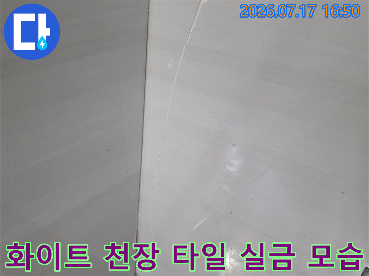 밝은 색상의 화장실 천장 마감재 위에 발생한 가느다란 직선형 균열 사진