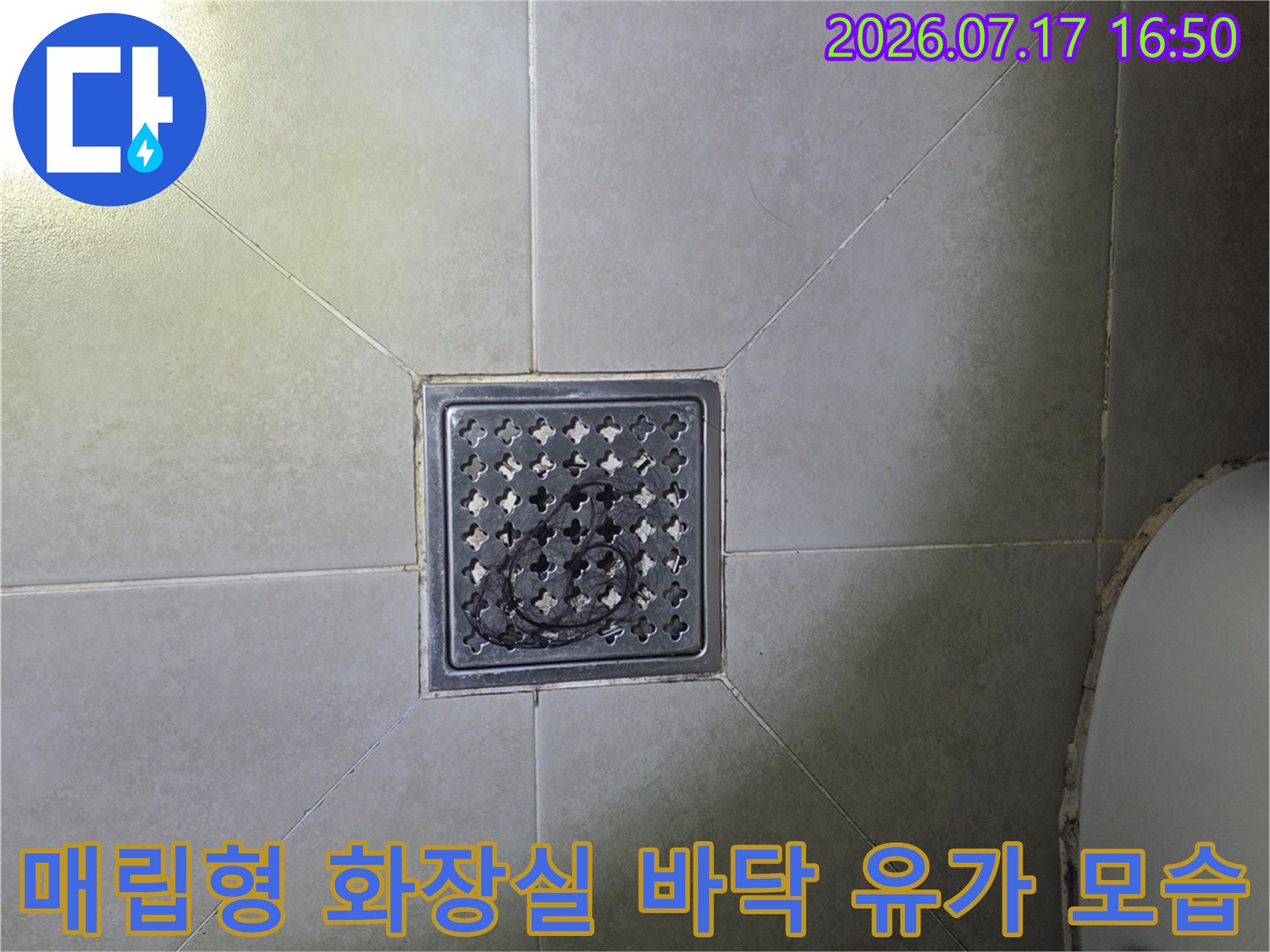 회색 타일 floor에 설치된 금속제 사각형 배수구-탑뷰 사진
