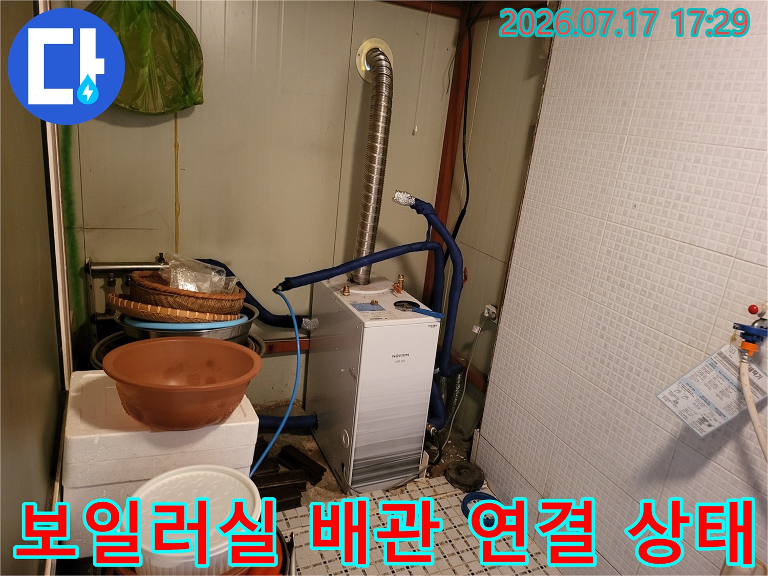흰색 보일러 기계-파란색 유연한 배관-은색 자바라 연통의 연결 모습