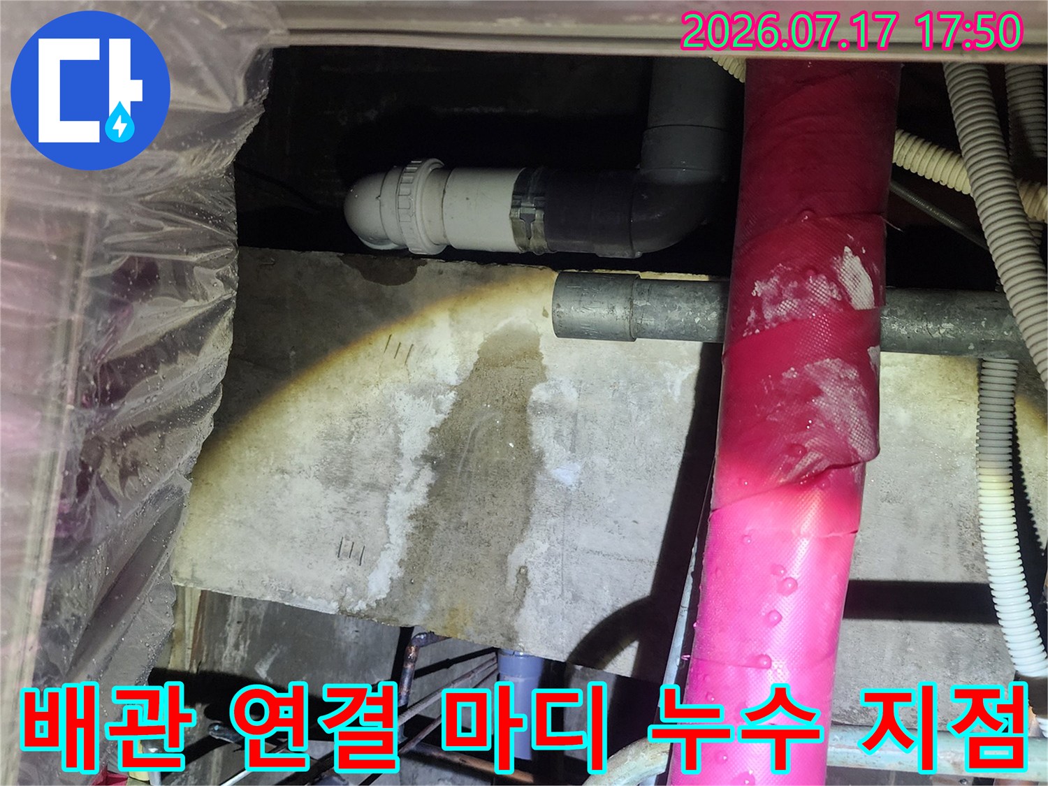 분홍색 보온재 배관 아래로-연결 상태가 불량한 회색 하수 배관의 모습