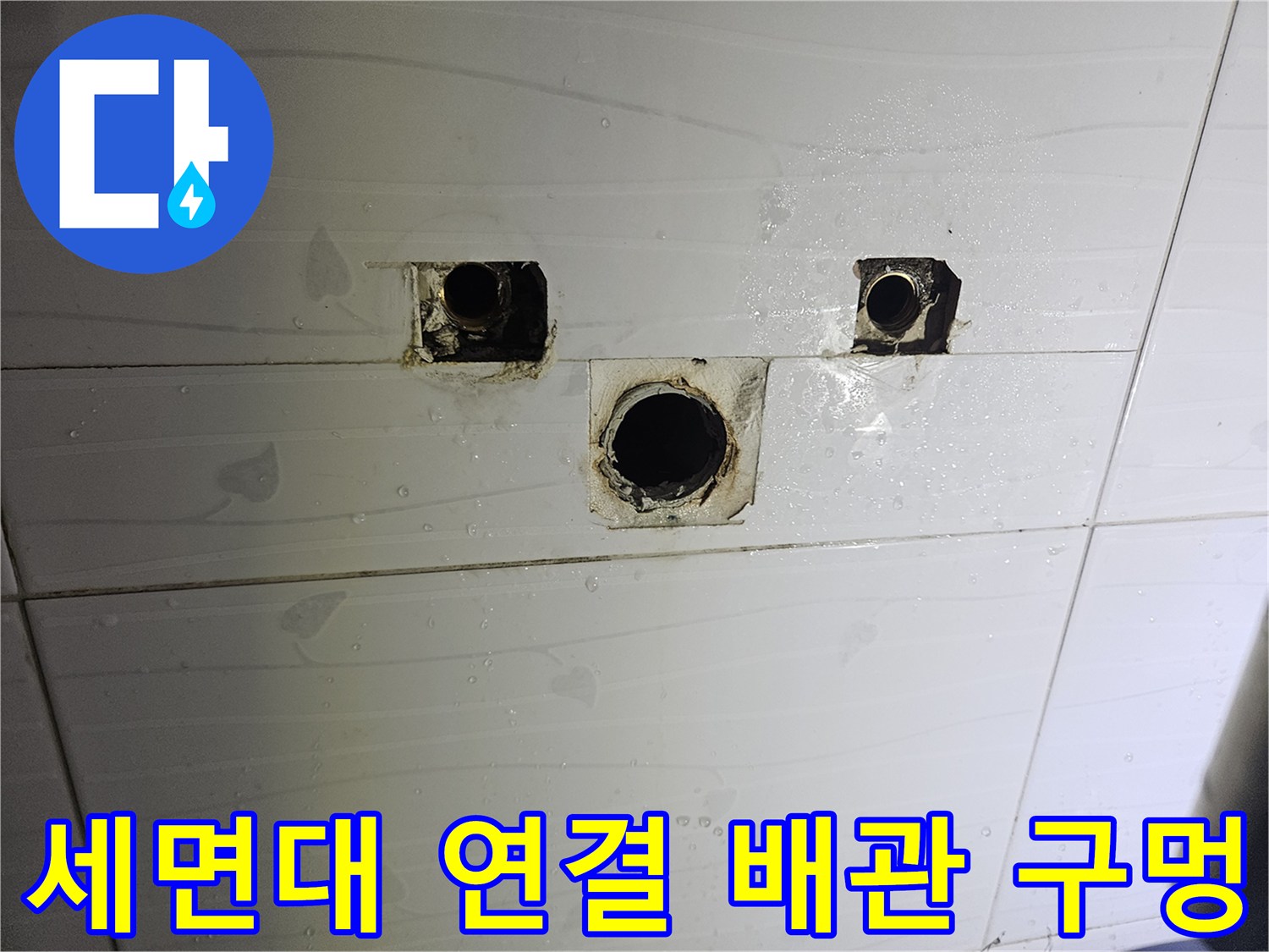 벽면 타일 사이로 노출된 세면대용 배관 연결 부위