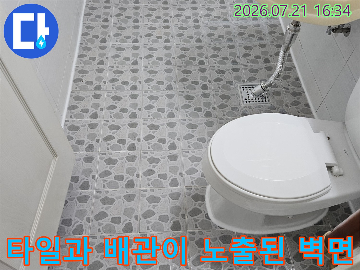 변기 측면 타일벽과 연결된 수도 및 배수 배관의 점검 모습