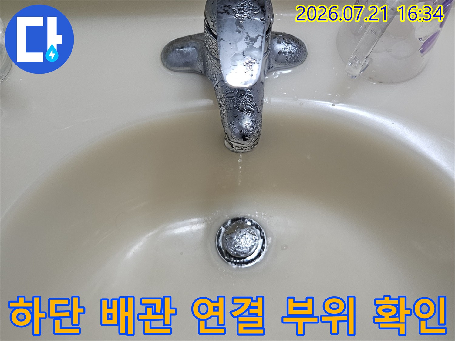 세면대 아래부의 금속 밸브와 파이프가 연결된 구간을 촬영한 모습