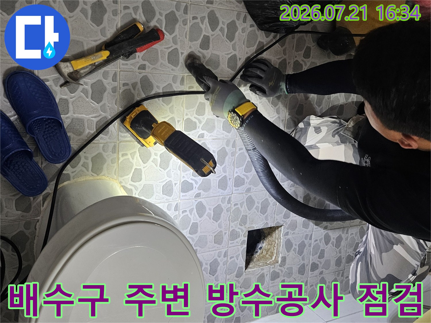 전문가가 배수구 근처의 누수 경로를 정밀 장비로 추적하는 현장 사진