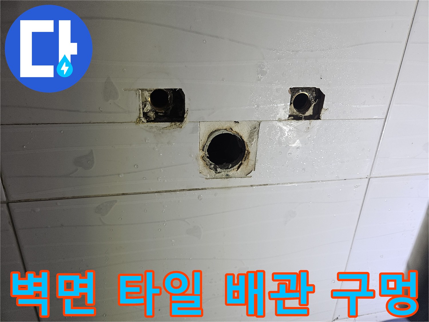 타일 벽면에 노출된 세면대 하부 배관 연결부