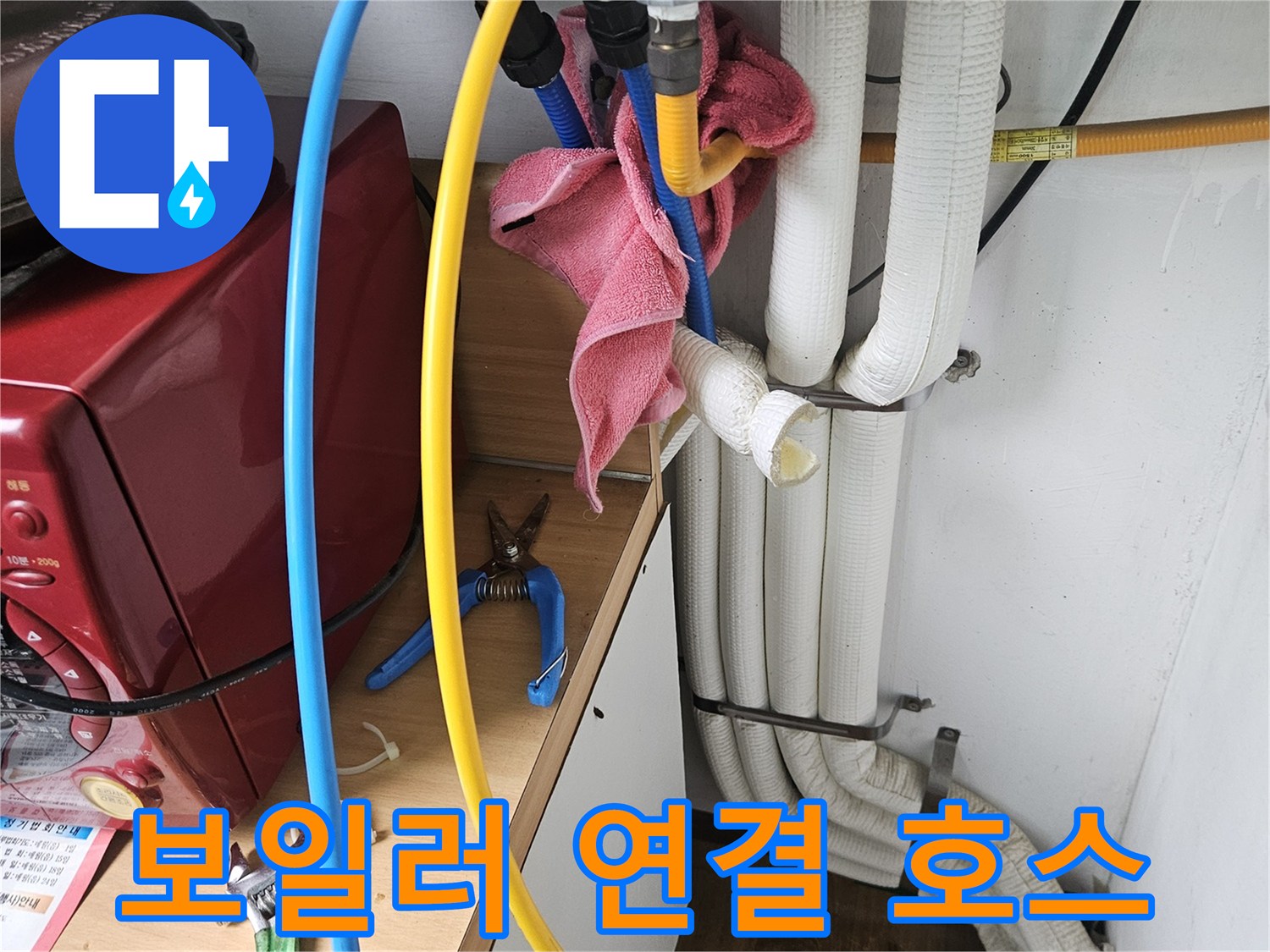 파란색-및-노란색-호스가-연결된-보일러-하단