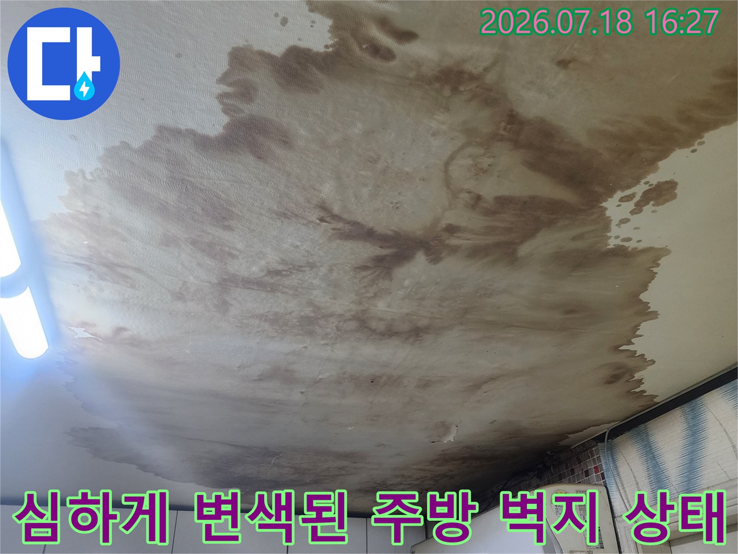 에어컨 하단부터 넓게 퍼진 갈색 누수 얼룩과 젖은 벽지의 모습