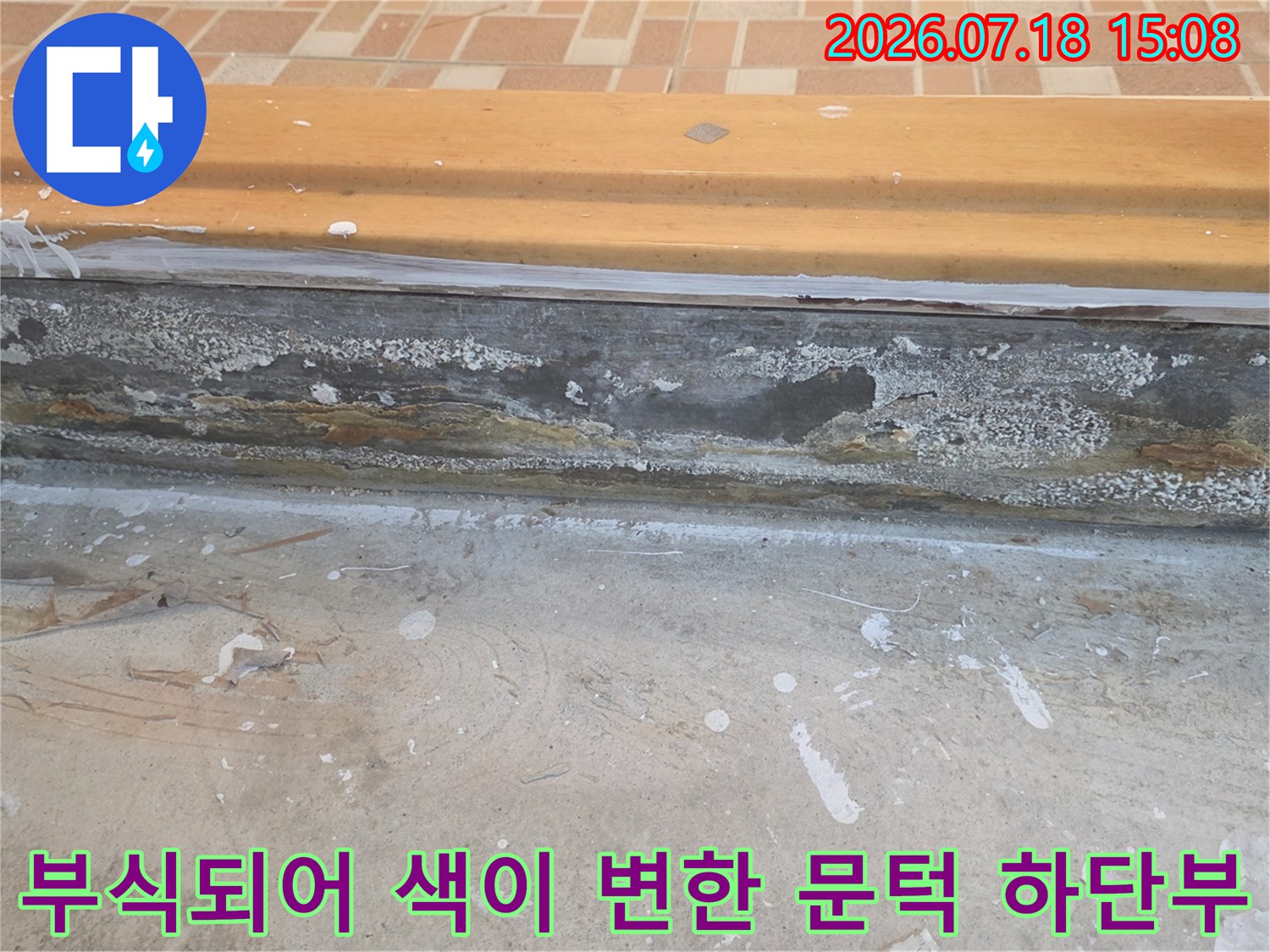 습기에 젖어 부풀고 검게 변색된 화장실 입구의 나무 문턱 사진
