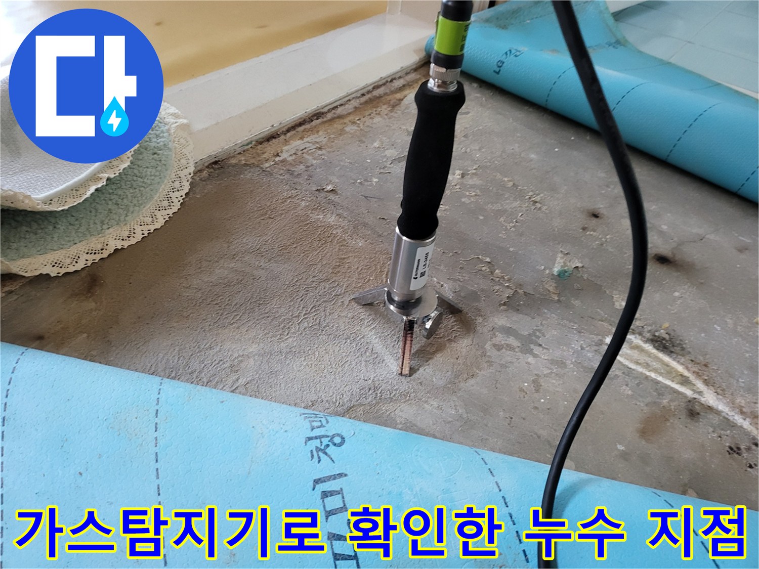 가스 탐지기를 사용하여 바닥 아래 배관의 누수 위치를 찾는 모습입니다.