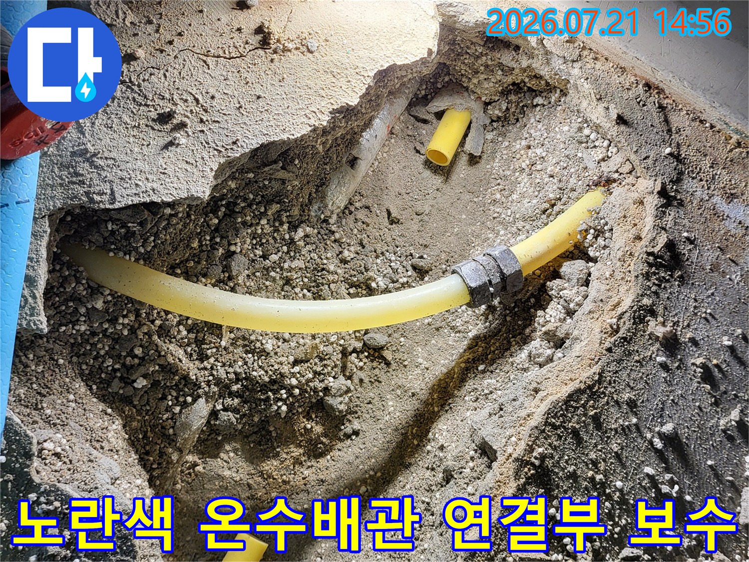 온수 배관의 손상된 연결부를 노출하고 교체 준비를 하는 공사 장면